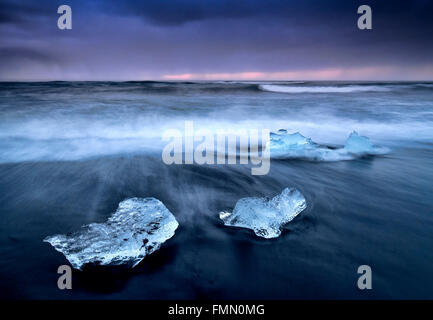 Icebergs en la playa volcánica de Fellsfjara al atardecer, cerca de Jokulsarlon, en el sur de Islandia Foto de stock