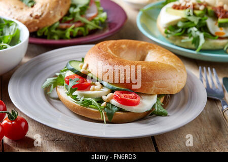 Sandwich bagel fresco sobre la mesa de madera