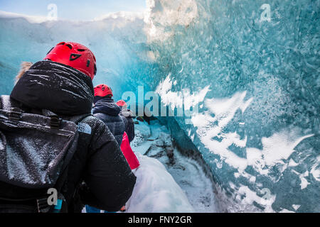 La gente en la entrada de una cueva de hielo, Parque Nacional, el glaciar de Vatnajökull, Islandia