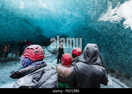 La gente en la entrada de una cueva de hielo, Parque Nacional, el glaciar de Vatnajökull, Islandia