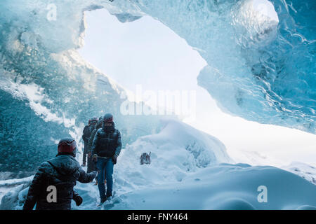 La gente en la entrada de una cueva de hielo, Parque Nacional, el glaciar de Vatnajökull, Islandia