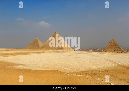 Las pirámides de Giza, estructuras hechas por el hombre del Antiguo Egipto en las doradas arenas del desierto con la contaminación de El Cairo en la backgr