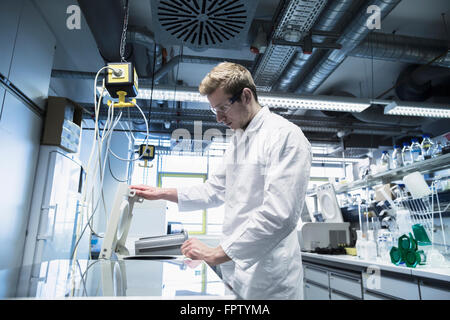 Macho joven científico que trabaja en una farmacia, laboratorio, Friburgo de Brisgovia, Baden-Wurtemberg, Alemania