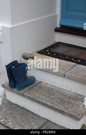 Azul del niño botas Wellington en la puerta. Foto de stock