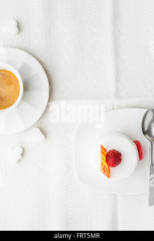 Pastel blanco con frambuesa y vertical de café Foto de stock