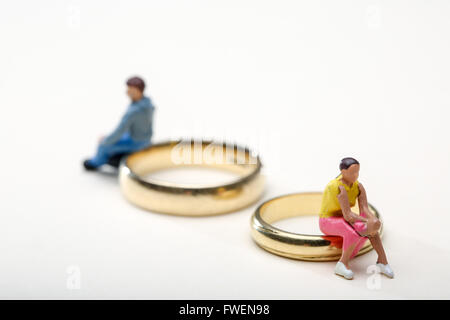 Concepto de imagen una pareja se sentó sobre los anillos de bodas para ilustrar el divorcio y separación