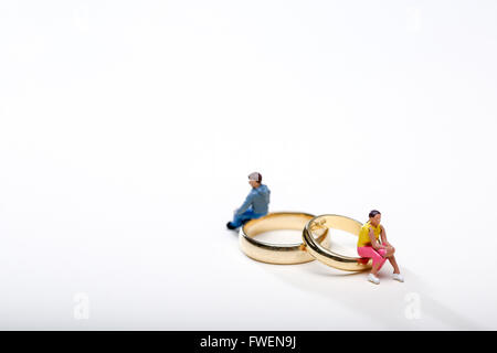 Concepto de imagen una pareja se sentó sobre los anillos de bodas para ilustrar el divorcio y separación