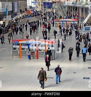 Vista desde arriba mirando hacia abajo a los viajeros en la estación Waterloo de Londres concourse con dos filas de máquinas expendedoras de billetes de autoservicio Inglaterra Foto de stock