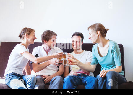 Grupo de Amigos vitoreando en casa, la gente sonriente joven feliz con bebidas, copyspace