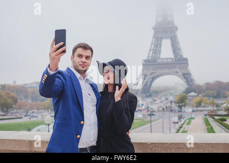 Par de turistas tomando fotos con la Torre Eiffel de Paris, selfie, turismo en Europa, Francia