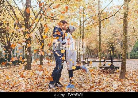 Beso de otoño, la joven pareja amorosa en el parque con la caída de las hojas Foto de stock