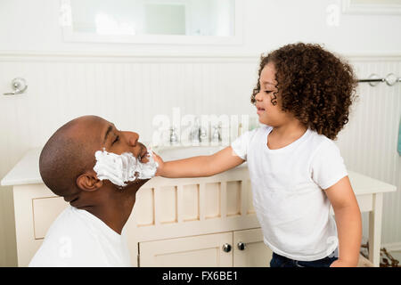 Boy ayudar padre afeitar en el baño. Foto de stock