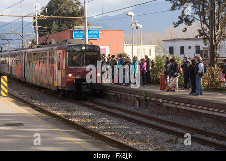 Pasajeros que esperan el tren de Sorrento a Nápoles en la línea Circumvesuviana en la estación de tren de Pompeya - Pompeya Scavi-Villa dei Misteri, Italia