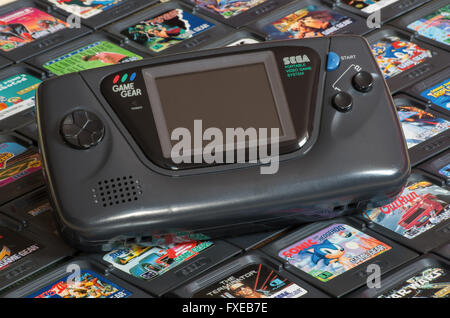 La SEGA Game Gear sistema de videojuegos portátil sobre una cama de cartuchos, incluidos videojuegos Sonic the Hedgehog y Star Wars Foto de stock