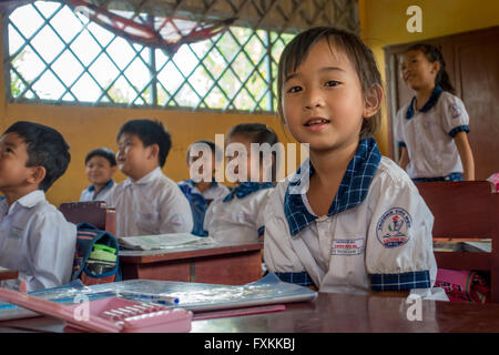 Los niños de la escuela en uniforme escolar el aprendizaje escolar en una pequeña aldea en el Delta del Mekong, Vietnam Foto de stock