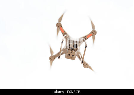 Quadrocopter drone volando sobre un fondo blanco. Foto de stock