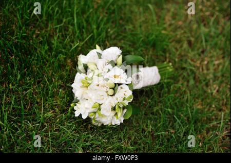 Boda nupcial bouquet blanco sobre la hierba verde