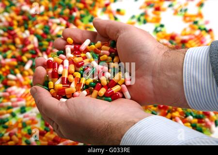 Las manos llenas de medicamento píldora cápsulas Foto de stock