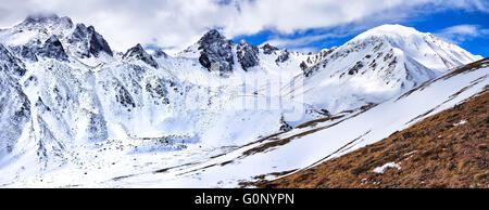 Picos de montaña de Sayan oriental a finales de abril. Pico de constitución ( 2971 m) en el medio y pico - Tyhen-Ardyn ( 3192 m) en le Foto de stock