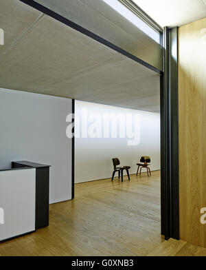 PX House, La Garriga, España. Vista de paredes en blanco y negro y dos sillas en el fondo, en el pasillo. Foto de stock