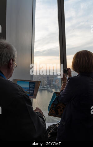 Turistas y visitantes admirando las vistas desde el observatorio del Centro Mundial de Comercio Justo antes de la puesta del sol Foto de stock