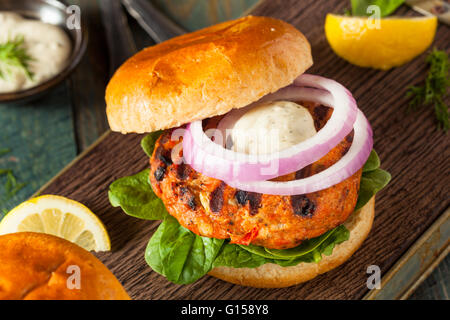 Hamburguesa de salmón casero con salsa tártara y cebolla Foto de stock