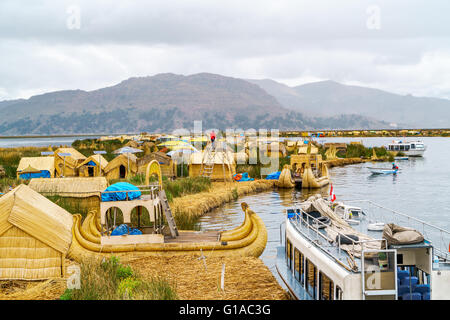 Ver en la isla flotante de Los Uros con los típicos botes en el Lago Titicaca, Puno, Perú Foto de stock
