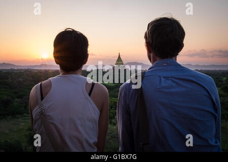 Un par ver desde la cima de un templo en Bagan, mientras el sol se pone. Foto de stock