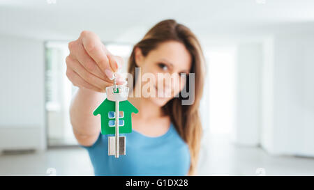 Hermosa Mujer sonriente sosteniendo llaves de casa de su nueva vivienda, bienes raíces y reubicación concepto