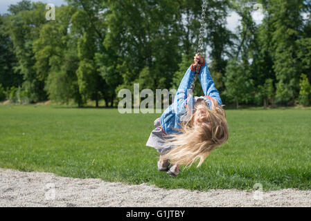 Niño feliz chica rubia (edad 5) se deshace en Flying Fox el equipo para jugar en un playground para niños. Verano Foto de stock