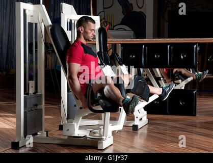Muy power athletic guy culturista ejecutar el ejercicio en el gimnasio oscuro Foto de stock
