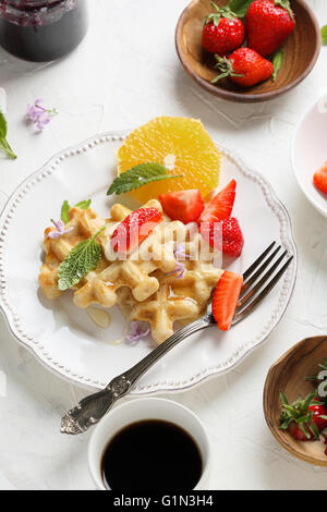 Waffles belgas con fresas en la placa blanca. Foto de stock