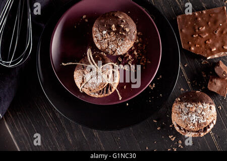 El italiano maroni cookies en la placa y batidos de chocolate, tela, portátil en el fondo antiguo de madera oscura, vista superior Foto de stock