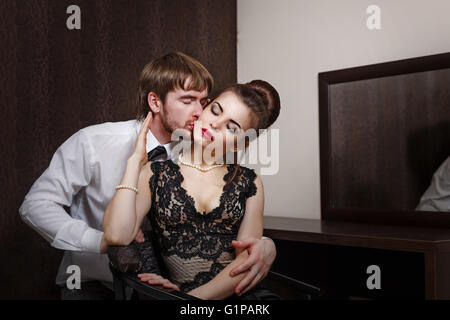 Pareja casada. Noche romántica en el hotel. Amor y pasión. El hombre abraza y tierno besa a su esposa en el cuello Foto de stock