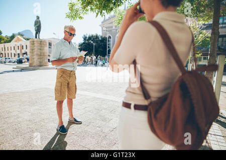 Altos hombre fotógrafo por una mujer en la ciudad durante sus vacaciones. Las parejas ancianas tomando fotos en sus vacaciones.