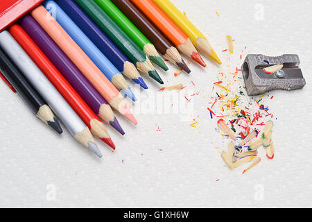 Closeup en coloridos lápices para dibujar y el afilador en una toalla de papel blanco