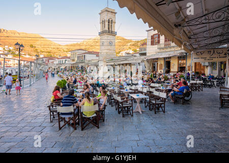 Cuando se pone el sol sombra toldos se revierten sobre las tabernas y cafés a lo largo Town Waterfront, Hydra Hydra, Grecia Foto de stock