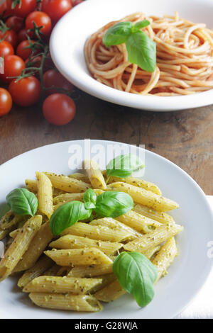 Dos platos de pasta con pesto y salsa de tomate Foto de stock