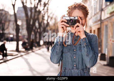 Foto de muchacha enfocada bonita vestida ropa naranja elegante sentada  meditación de yoga en el piso aislado en fondo de color cian Fotografía de  stock - Alamy