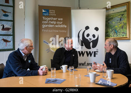 El Primer Ministro David Cameron (centro) habla a CEO de RSPB, Mike Clarke (izquierda) y director general de WWF, David Nussbaun, antes de ser mostradas en torno Rainham marismas RSPB Nature Reserve por impresionista Alistair McGowan. Foto de stock