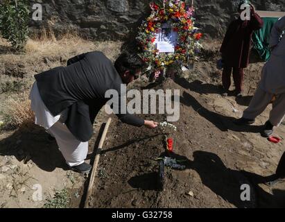 Kabul, Afganistán. El 7 de junio de 2016. Un pariente pone flores en la tumba de Zabihullah Tamana durante su funeral en Kabul, capital de Afganistán, 7 de junio de 2016. David Gilkey de EE.UU. la Radio Pública Nacional (NPR) y su traductor Zabihullah Tamana fueron muertos como militantes atacaron un convoy del ejército afgano en el sur de la provincia de Helmand, el domingo. Tamana, de 38 años, había servido como reportero para la agencia de noticias Xinhua oficina en Kabul desde 2003 a 2010. © Rahmat Alizadah/Xinhua/Alamy Live News