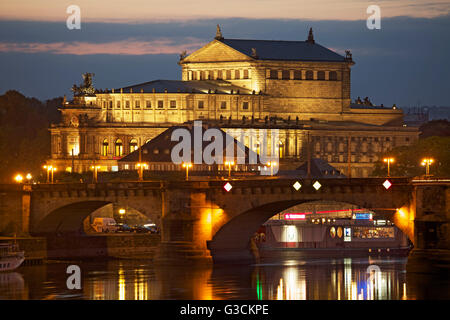 Vista sobre el río Elba al iluminado Opera Semper de Dresden, en la noche, delante de él, el Augustus puente,