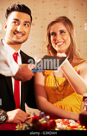 3 Personas a las parejas casadas y el camarero extranjero hotel cena dando facturas Foto de stock