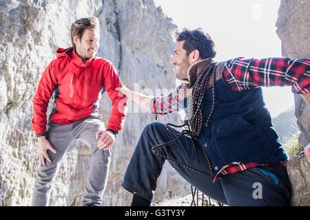 Dos montañeros descansando durante una ascensión en terrenos accidentados. Foto de stock