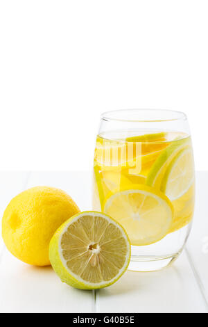 Agua con limón y en una vista en el lateral de la mesa de vidrio de aislamiento.limonada fresca y saludable. Foto de stock