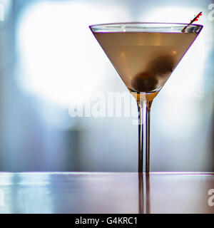 Dirty Martini sentado en una barra retroiluminada.