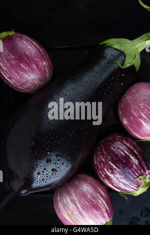 Húmedo y negro a rayas púrpura berenjenas extreme closeup. Vista superior, imagen vertical Foto de stock