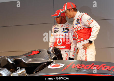 Los pilotos Lewis Hamilton (izquierda) y Jenson Button (derecha) posan para una fotografía con el Vodafone McLaren Mercedes MP4-27 en el McLaren Technology Center, Woking. Foto de stock