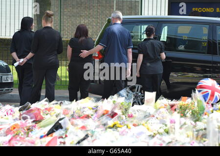 Los familiares de Drummer Lee Rigby se marchan después de que miraran los homenajes florales en las afueras de Woolwich Barracks mientras visitaban la escena de su asesinato en Woolwich, al sudeste de Londres. Foto de stock