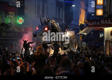 Acrobáticos zancos, pirotecnia y dragones gigantes en movimiento que presentan los sonidos de una partitura de rock-opera interpretada por músicos en vivo en un espectáculo llamado 'Dragonus' mientras atraviesan las calles de Galway como parte del Festival Internacional de Arte de Galway. Foto de stock